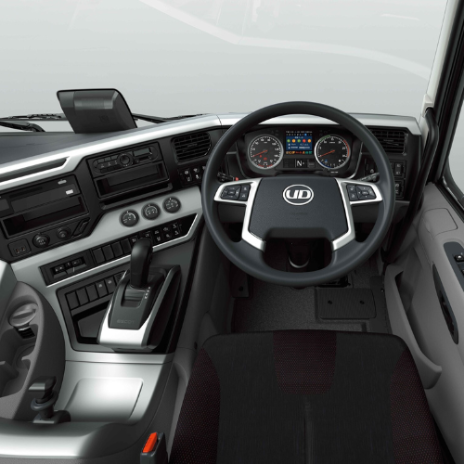 Modern truck dashboard and steering wheel with digital display and control buttons.