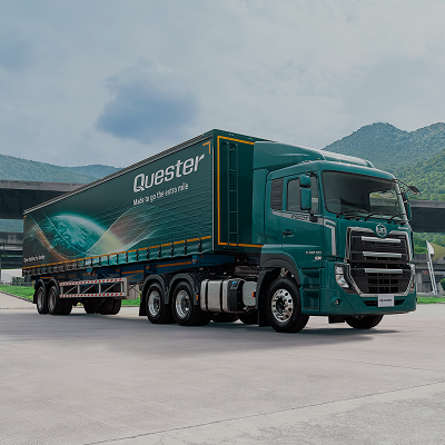 Groot groen vragmotor met sleepwa op parkeerarea, berge agtergrond