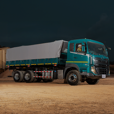 Lori kubwa ya bluu na kijivu imesimama kwenye mchanga usiku.