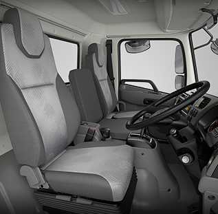 Two grey fabric seats inside a truck cab, with steering wheel and dashboard visible.