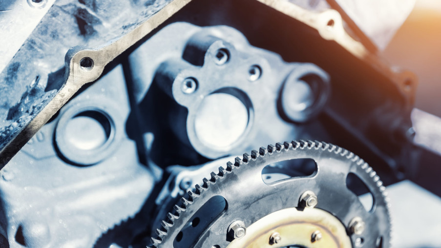 Close-up of a metallic engine component with gears and bolts.
