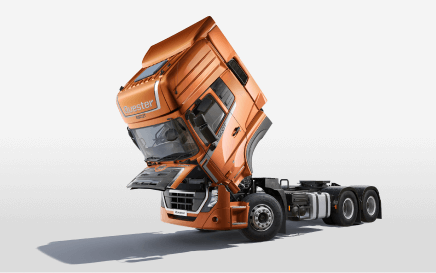 Truk oranye dengan kabin depan terangkat, latar belakang putih polos.