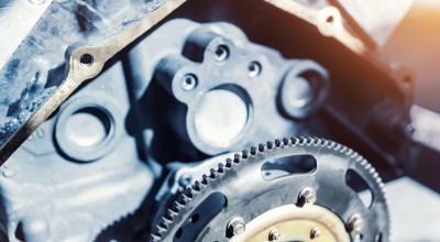 Close-up of a metallic engine component with gears and bolts.