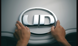 両手で触れているUDトラックスのロゴエンブレム